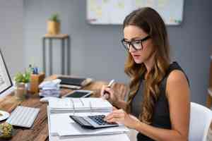 © Andrey Popov / stock.adobe.com Frau mit Taschenrechner